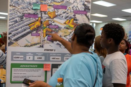 Participants look at a posterboard of development options during the Cabrini Now public planning process 